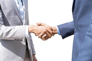 Businessmen shaking hands. Unknown businesspeople are shaking their hands after signing a contract, while standing together.