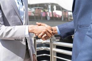 Businessmen shaking hands. Unknown businesspeople are shaking their hands after signing a contract, while standing together. photo