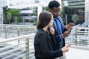 grupo de gente de negocios. gente de negocios reunida hablando y compartiendo sus ideas en la ciudad. equipo de negocios y concepto de trabajo en equipo. empresarios parados afuera en la ciudad discutiendo sobre un nuevo proyecto. foto