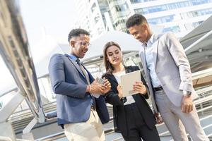 Group of business people.Business people meeting talking and sharing their ideas in city. Business team and teamwork concept. Business people standing outside in the city discussing about new project. photo