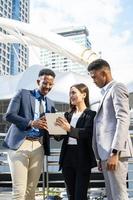 Group of business people.Business people meeting talking and sharing their ideas in city. Business team and teamwork concept. Business people standing outside in the city discussing about new project. photo