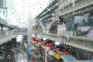 Morning city,view through the window on rainy day. Water droplets on the glass on a rainy day. rain drops during raining in rainy day outside window glass with blurred background. photo