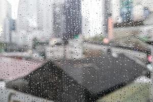 ciudad de la mañana, vista a través de la ventana en un día lluvioso. gotas de agua en el vaso en un día lluvioso. gotas de lluvia durante la lluvia en un día lluvioso fuera del cristal de la ventana con fondo borroso. foto