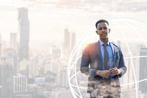 gente de negocios en la ciudad. retrato de un apuesto hombre de negocios. hombre de negocios moderno. joven seguro de sí mismo con traje completo y gafas mientras está de pie al aire libre mirando hacia otro lado con el paisaje urbano en el fondo foto