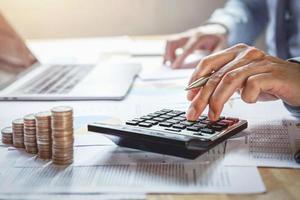businessman working on desk with using calculator for calculate finance and accounting in office photo