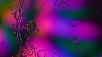 huile alimentaire colorée abstraite gouttes bulles et sphères coulant sur la surface de l'eau, vidéographie macro