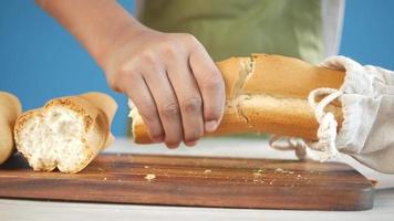 young men breaking a long bread of loaf video