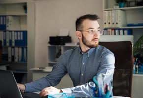 hombre de negocios trabajando en su computadora portátil en una oficina foto