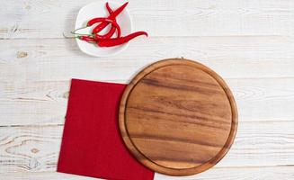 Napkin and board for pizza on wooden desk closeup, tablecloth. Canvas, dish towels on white wooden table background top view mock up. Selective focus photo