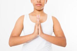 Close-up of hands of black woman in white clothes meditating indoors, focus on arms in Namaste gesture.Mock up. Copy space. Template. Blank. photo