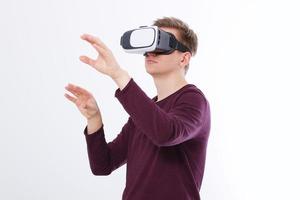 Excited young man in a VR headset, glasses. Virtual reality isolated on white background. Copy space and mock up photo