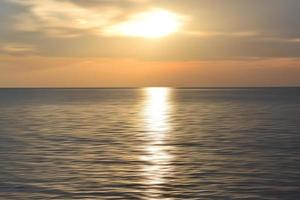 Sunset over the ocean. Blurry ocean landscape background and sunset view. Blurry abstract art background in digital motion effect. photo