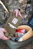 Military army first aid kit. Camouflaged soldier medic. photo