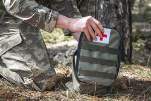 Military army first aid kit. Camouflaged soldier medic. photo