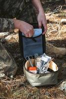 Military army first aid kit. Camouflaged soldier medic. photo