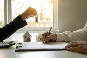 el cliente está firmando un contrato de bienes raíces con un formulario de solicitud de hipoteca aprobado. ideas de préstamos hipotecarios y seguros de vivienda. foto
