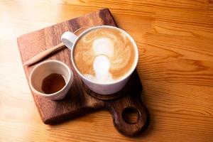 Hot Latte in a white coffee cup on a wooden table. photo