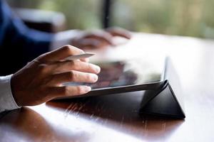 Close up of man's hand using a pen and a laptop. photo