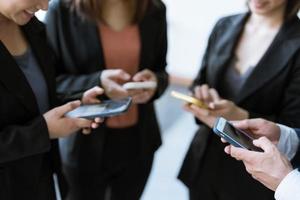 grupo de jóvenes empresarios de pie y usando teléfonos inteligentes juntos conceptos de comunicación. foto