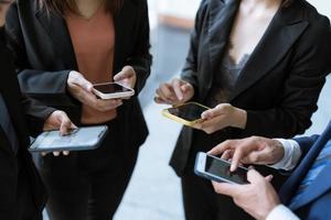 Group of young business people standing and using smartphone together concepts communication. photo