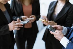 Group of young business people standing and using smartphone together concepts communication. photo