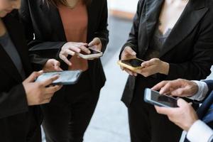 grupo de jóvenes empresarios de pie y usando teléfonos inteligentes juntos conceptos de comunicación. foto