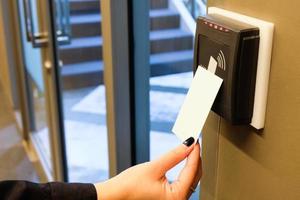 Women hand reaching to use RFID key card to access to office building area and workspace. In building security only for authorized person photo