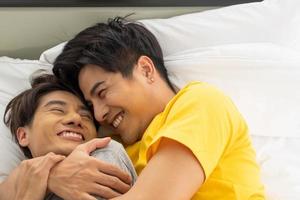 Asian gay homosexual couple hug and embracing on the bed.  Gender equality and right concept, playful and romantic moment. photo
