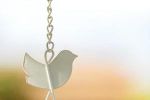 Close-up shape bird wind chime with hanging chains