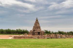 A distant view of the exterior facade of the ancient Shore Temple on a cloudy day. photo