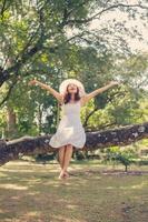 Young teen girl sitting on tree photo