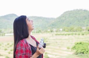 Young hipster woman photographer holding a vintage camera. photo