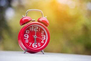 6 o'clock Clock Vintage on Wood Table with Sun Light photo