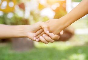 pareja feliz tomados de la mano en la puesta de sol foto