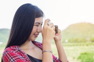 Young hipster woman photographer holding a vintage camera. photo