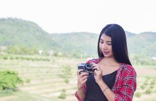 Young hipster woman photographer holding a vintage camera. photo