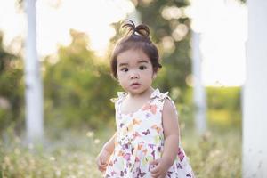 Cute girl smiling brightly in the setting sun photo