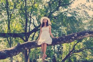 joven adolescente sentada en un árbol foto