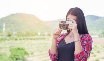 joven fotógrafa hipster sosteniendo una cámara vintage. foto