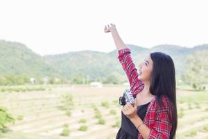 Young hipster woman photographer holding a vintage camera. photo