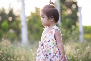 Cute girl smiling brightly in the setting sun photo