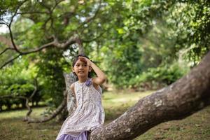 Little cute asian girl standing among the purple flower field sunshine day. Freedom enjoying with nature. photo