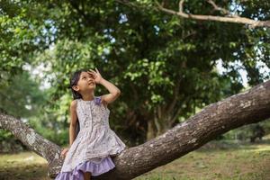 Little cute asian girl standing among the purple flower field sunshine day. Freedom enjoying with nature. photo