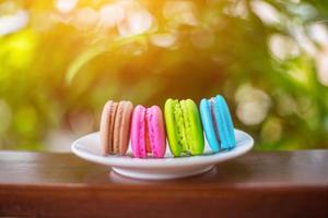 macarrones de san valentín con café en la mesa de madera. imagen tonificada foto