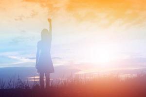 Silhouette of woman praying over beautiful sky background photo