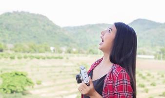 Young hipster woman photographer holding a vintage camera. photo