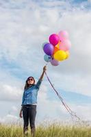 Beautiful Girl jumping with balloons on the beach photo