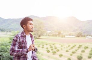 handsome hipster bearded man with cup of morning coffee walking in park. photo