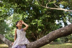 Little cute asian girl standing among the purple flower field sunshine day. Freedom enjoying with nature. photo