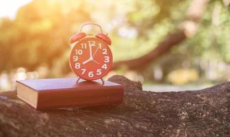 retro clock time at 8 o'clock with notebook or memo on wood table, times of memory writing diary concept vintage color tone. photo